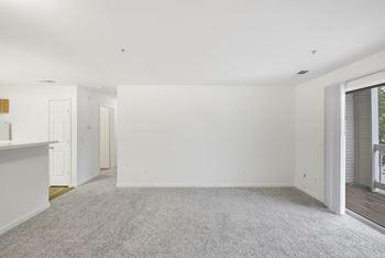 Spacious living room with carpet and balcony access